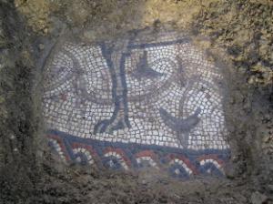The uncovered section of the mosaic reveals intricate  floor tiles which show the leg of an animal