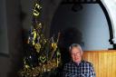 Richard Edgar admires the black and yellow colour scheme on the Christmas tree decorated by pupils at Ann Edward's school at the festival in All Hallows Church in South Cerney
