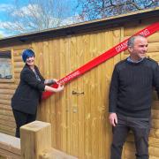 Natasha Biggs, funding administrator, from the Barnwood Trust cutting the tape off the new Men's Shed in South Cerney with Graham Harris, engagement worker, for The Churn Project.