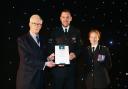 Sgt Jamie Ball (centre) received a certificate honouring his 20 years of service to Wiltshire Police