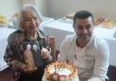 Leither Grimmer next to her birthday cake on her 100th birthday
