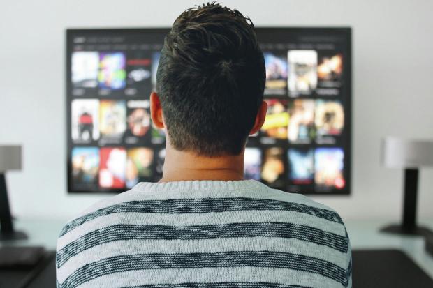 Wilts and Gloucestershire Standard: A man watching a smart TV. Credit: Canva