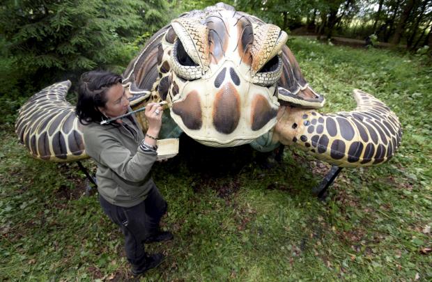 Wilts and Gloucestershire Standard: Coco Banks painting the sea turtle at Cotswold Sculpture Park. Photo: Paul Nicholls