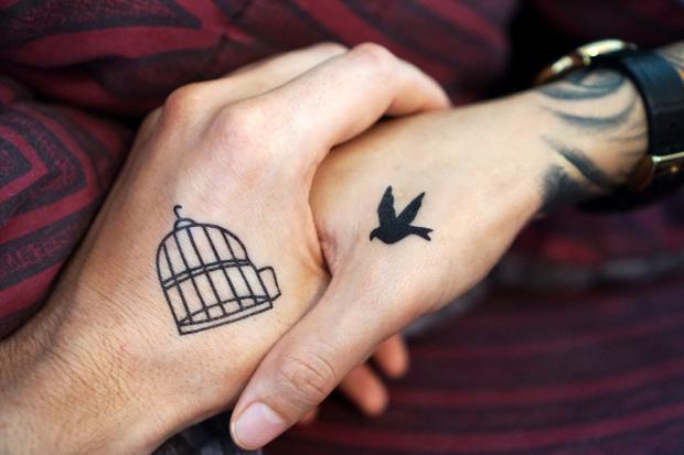 Wilts and Gloucestershire Standard: Two people with tattoos holding hands (Canva)