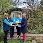 Mel Tanner, owner of The Coach House, Ampney Crucis, Cirencester receives a long service certificate and trowel to mark 10 years of opening her garden for the National Garden Scheme from Vanessa Berridge, County Organiser for Gloucestershire. Sarah