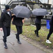 Elliot Benham (second left under umbrella) and Sophie Harvey (second right under umbrella) leaving Cheltenham Magistrates Court after a hearing in January last year