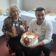 Leither Grimmer next to her birthday cake on her 100th birthday