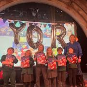 Pupils on the stage with Kemble Primary School headteacher Emma Morrogh-Ryan with signed copies of Shifty McGifty and Slippery Sam
