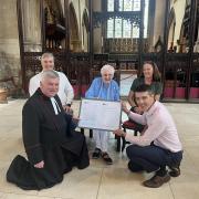 Canon Graham Morris and Matt Frost present Lucille Terry (centre) a framed certificate which celebrates her amazing academic achievements alongside her children Paul Terry and Rachel Hodges.